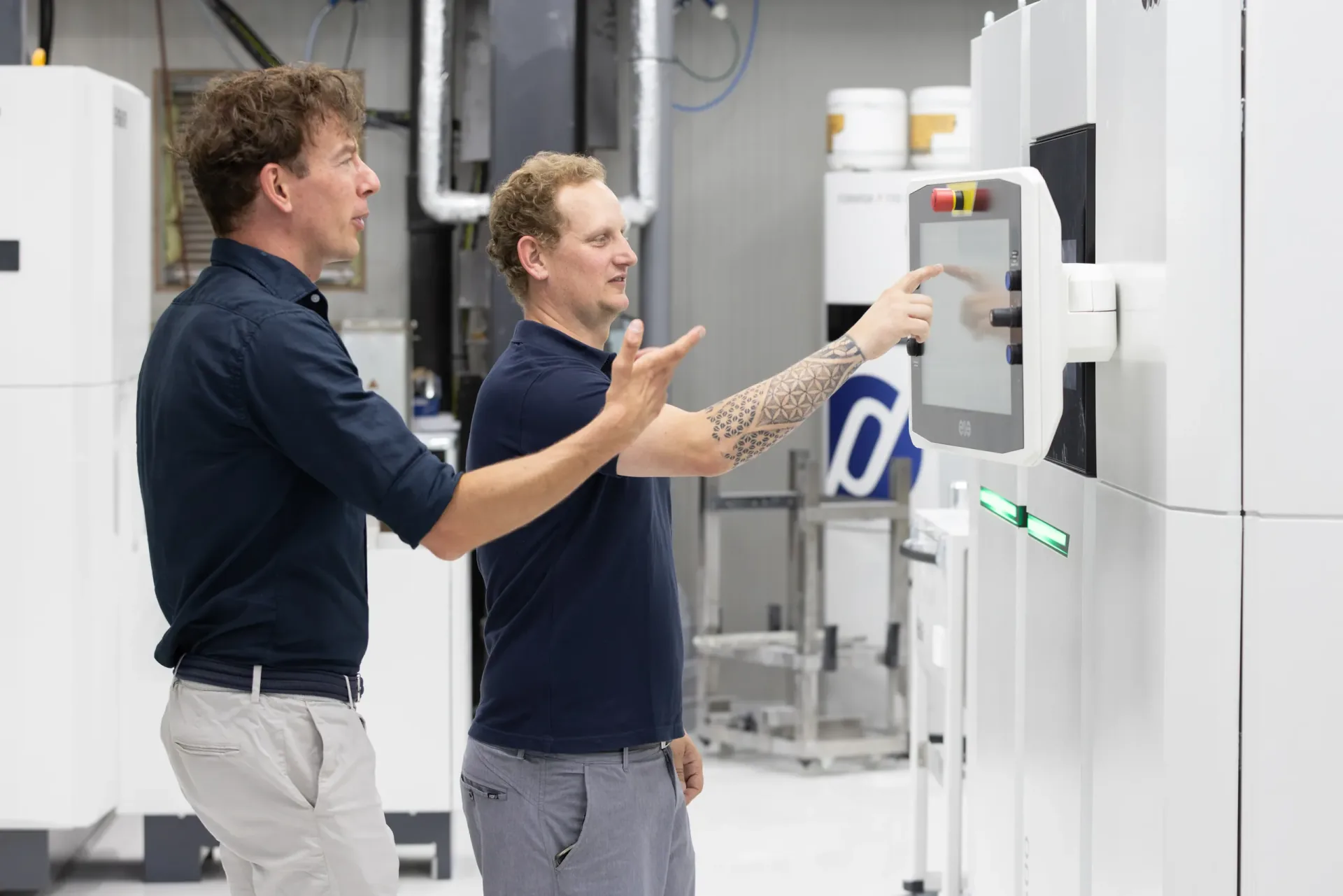 Engineers overleggen bij een SLS printer — Parts on Demand